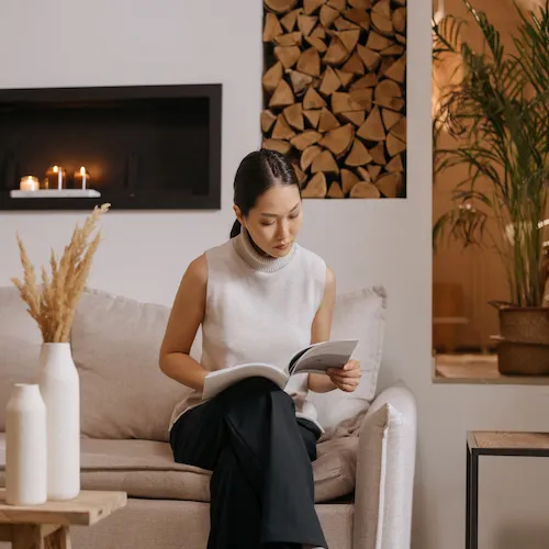 Woman sitting on a couch reading.