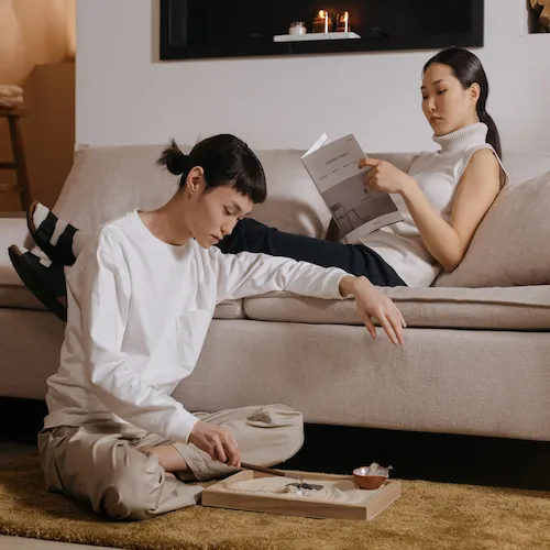 Woman reading book on couch and man sitting on floor.