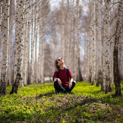 Woman sitting in woods.