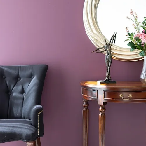 Purple paint on wall with mahogany furniture.