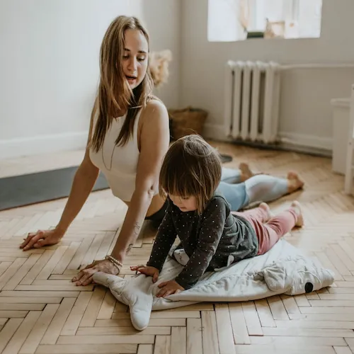 Woman and child exercising on floor.