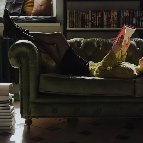 Woman relaxing on the sofa with a book.