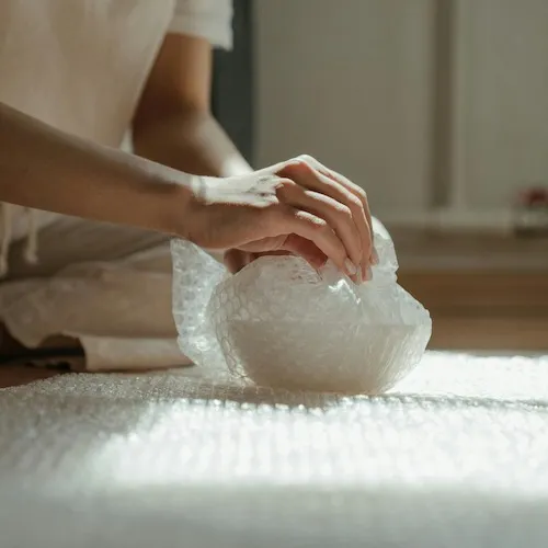 Person wrapping item with bubble wrap