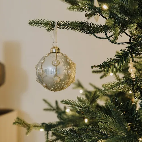 Gold, silver, and pearl-encrusted bauble hung on tree from EZ Living Furniture.