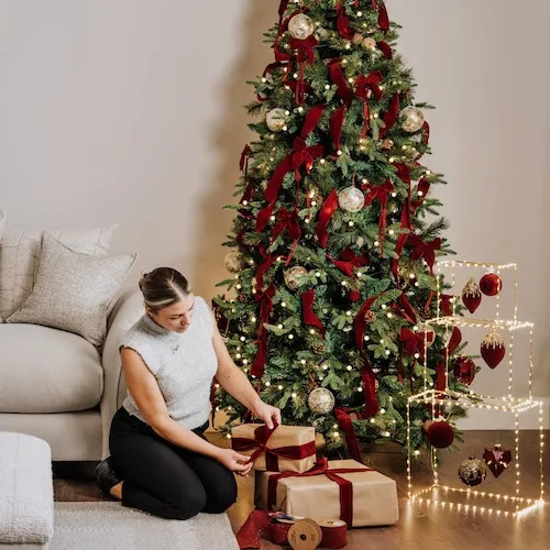 Gift wrapping in front of the Christmas tree.